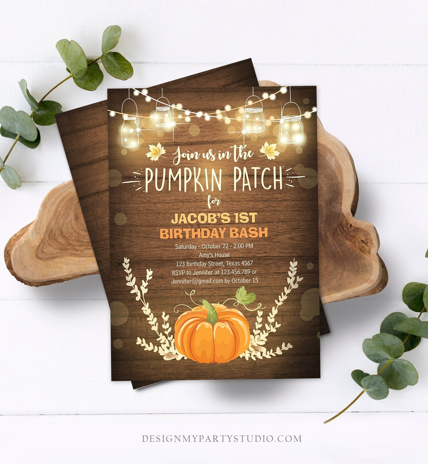 May include: A rustic wood background with a pumpkin patch birthday party invitation. The invitation is for Jacob's 1st birthday bash. The invitation has a pumpkin, fall leaves, and string lights. The text on the invitation reads: 'Join us in the Pumpkin Patch for Jacob's 1st Birthday Bash', 'Saturday - October 22 - 2:00 PM', 'Amy's House', '123 Birthday Street, Texas 4567', 'RSVP to Jennifer at 123.456.789 or Jennifer@gmail.com by October 15',