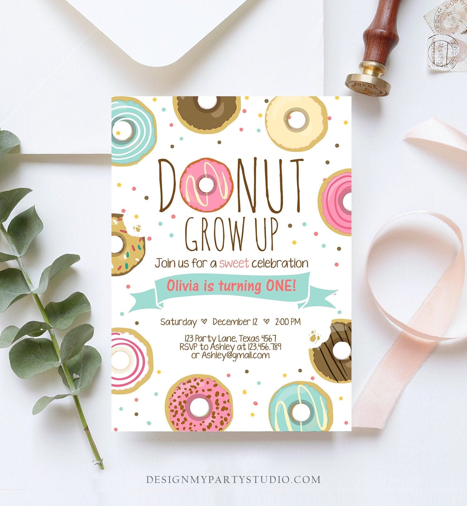 May include: Donut Grow Up birthday party invitation with a white background and colorful donut illustrations. The text reads 'Donut Grow Up', 'Join us for a sweet celebration', 'Olivia is turning ONE!', 'Saturday December 12 2:00 PM', '123 Party Lane, Texas 4567', 'RSVP to Ashley at 123.456.789 or Ashley@gmail.com', and 'DESIGNMYPARTYSTUDIO.COM'.