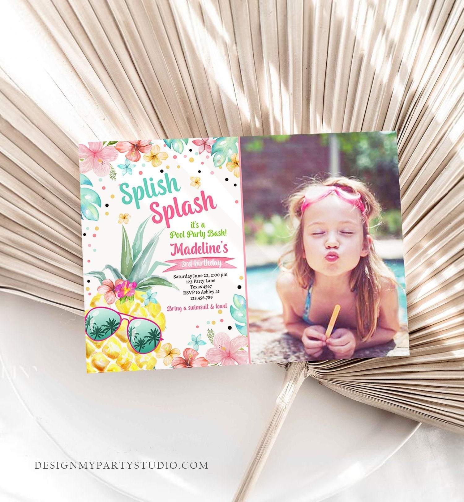 May include: A birthday invitation with a pineapple, flowers, and confetti. The invitation is for a pool party for Madeline's 3rd birthday. The text on the invitation reads: 'Splish Splash it's a Pool Party Bash! Madeline's 3rd Birthday. Saturday June 12, 3:00 pm 123 Party Lane Texas 4167 RSVP to Ashley at 113.456.399 Bring a swimsuit & towel. DESIGNMYPARTYSTUDIO.COM'