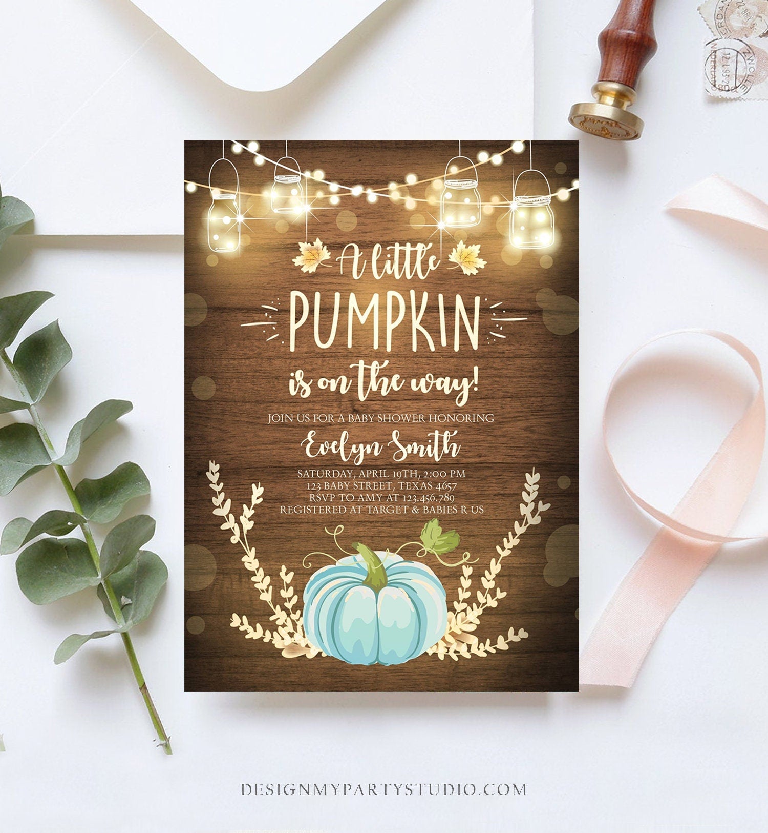 May include: A baby shower invitation with a rustic wood background and a blue pumpkin. The invitation reads &#39;A little pumpkin is on the way!&#39; and includes the name &#39;Evelyn Smith&#39;, the date and time of the shower, the address, and RSVP information. The invitation also includes the text &#39;Registered at Target & Babies R Us&#39;.
