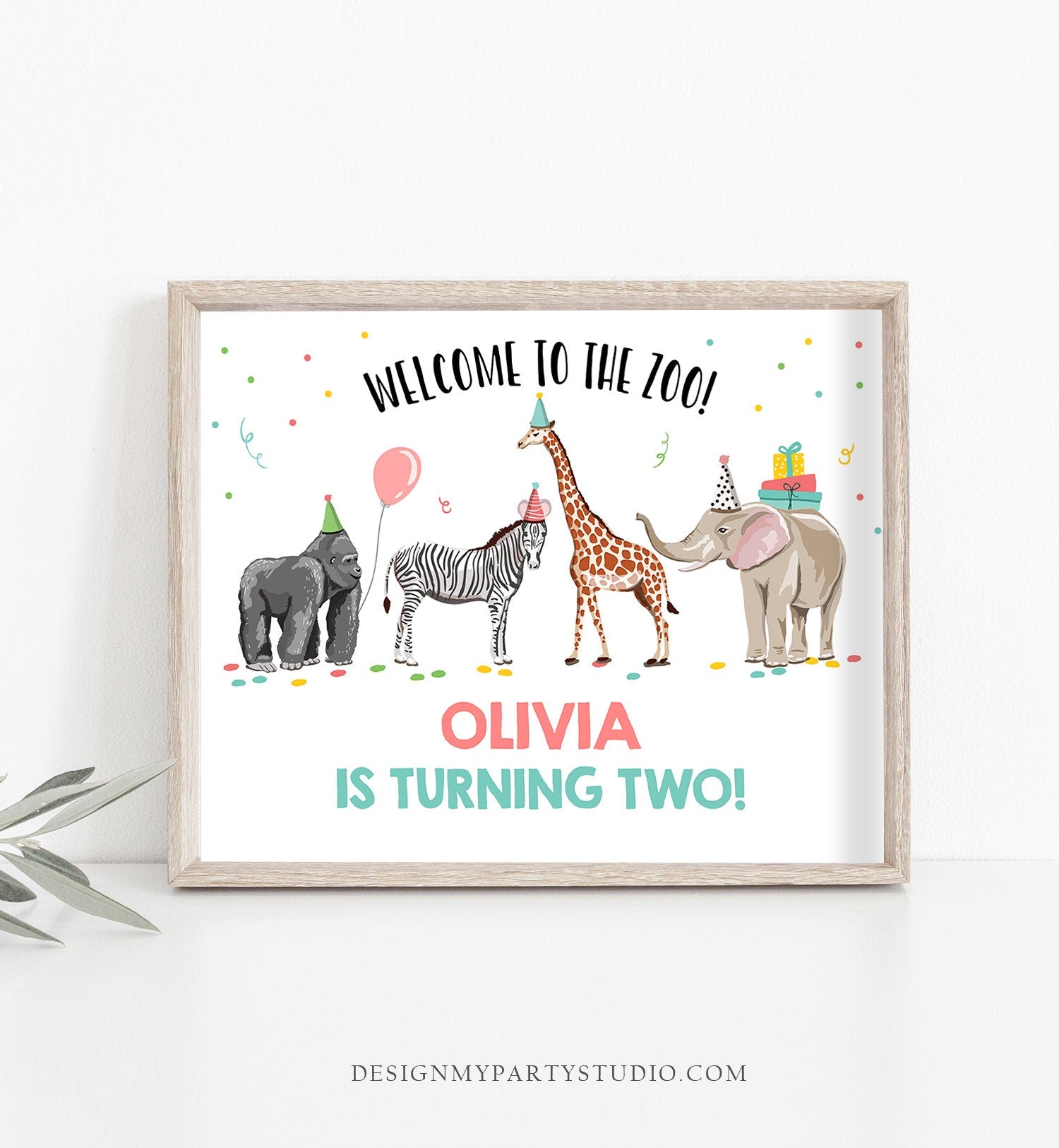 May include: Welcome to the Zoo! Olivia is turning two! A white sign with a colorful illustration of a gorilla, zebra, giraffe, and elephant wearing party hats. The sign has confetti and a pink balloon. The text is in black, pink, and teal.