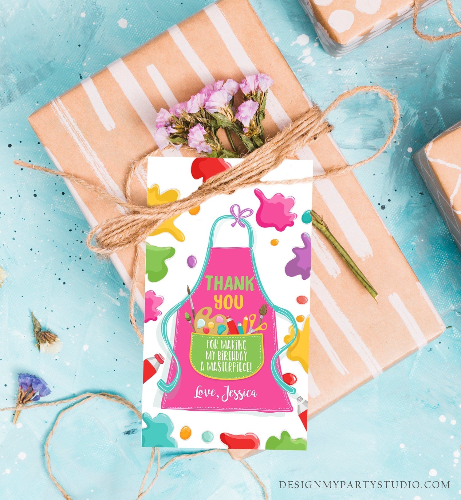 May include: A thank you tag with a pink apron design and colorful paint splatters. The text on the tag reads &#39;Thank You for making my birthday a masterpiece! Love, Jessica.&#39;