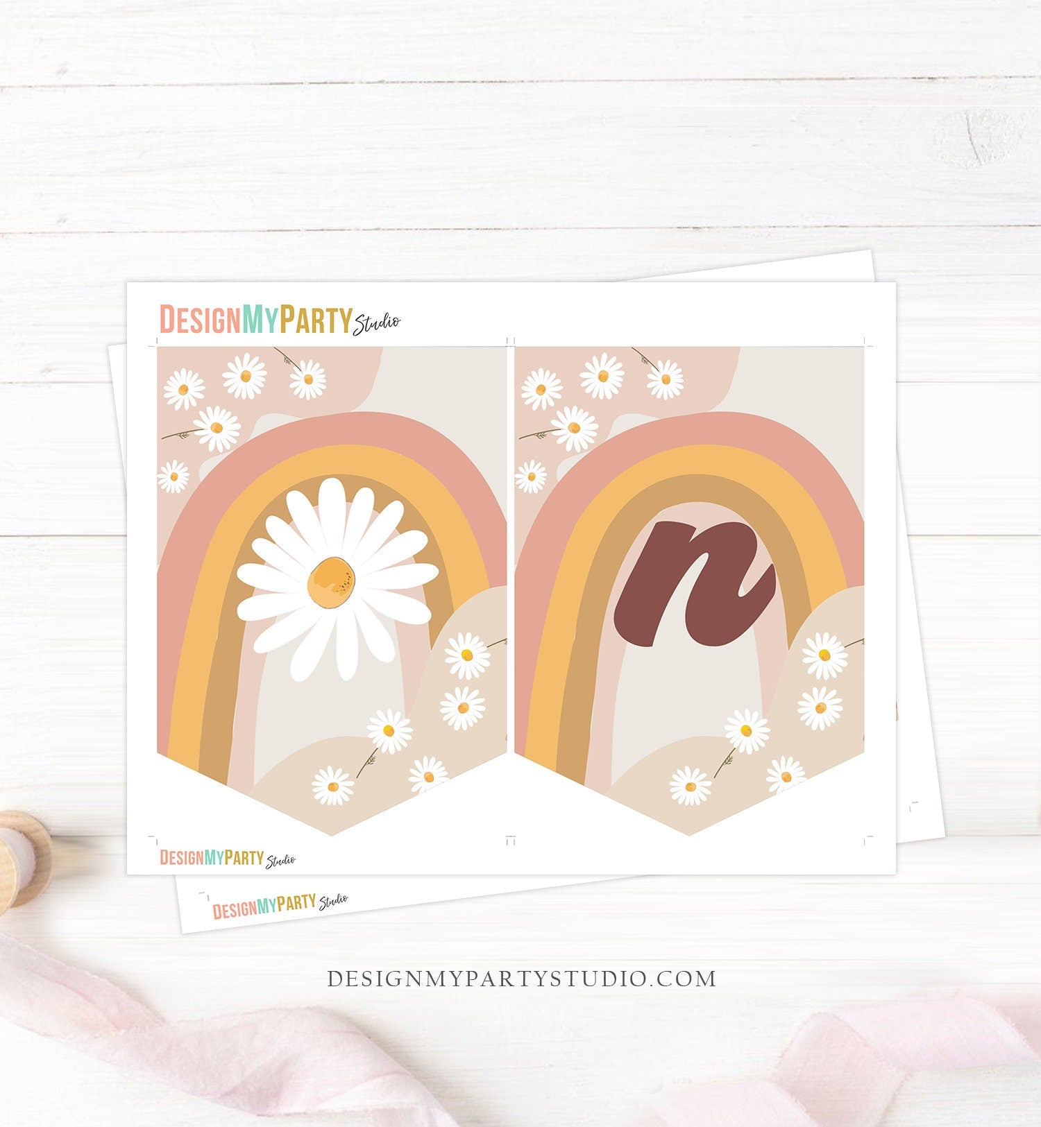 May include: A high chair decorated with a banner that says &#39;one&#39; in brown letters. The banner is made of three pennants with a rainbow and daisy pattern. The pennants are attached to the high chair with pink and white ribbon.