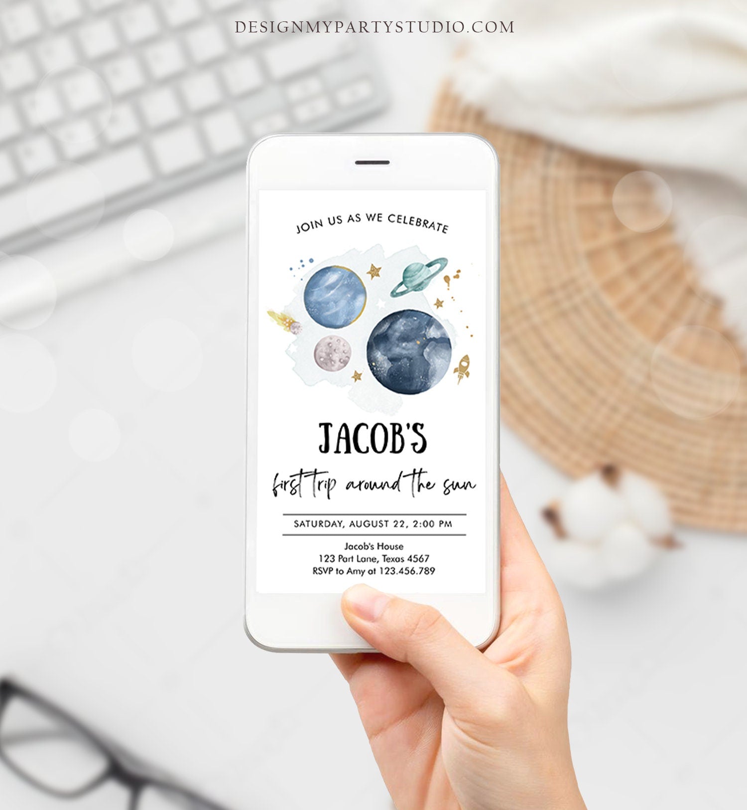 May include: A smartphone mockup with a blue and green space-themed birthday party invitation. The invitation reads &#39;Join us as we celebrate Jacob&#39;s first trip around the sun. Saturday, August 22, 2:00 PM. Jacob&#39;s House, 123 Part Lane, Texas 4567. RSVP to Amy at 123.456.789.&#39;