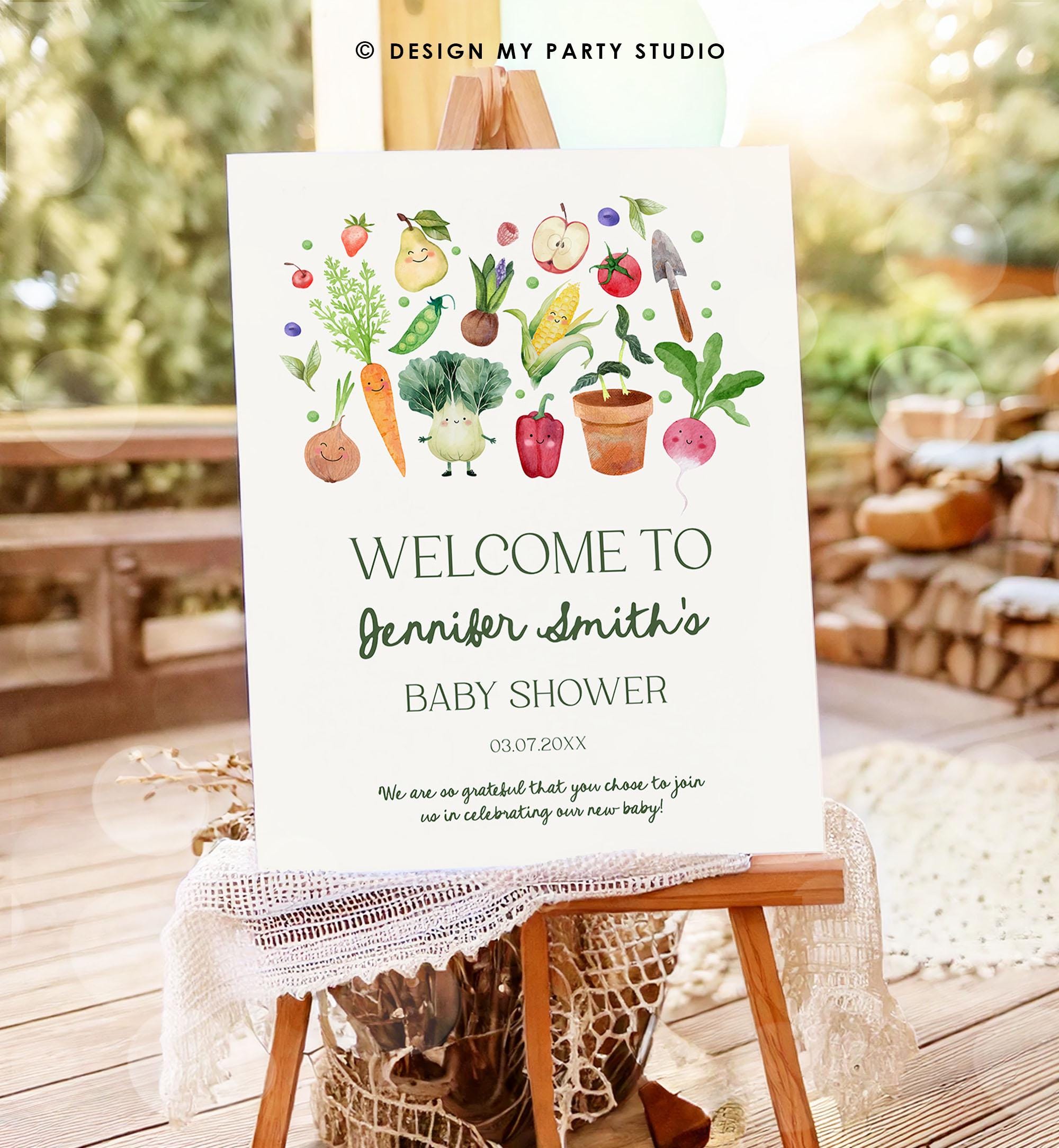 May include: A welcome sign for a baby shower with a green and white color scheme. The sign has a watercolor illustration of various vegetables and fruits with smiling faces. The text on the sign reads &#39;Welcome to Jennifer Smith&#39;s Baby Shower 03.07.20XX We are so grateful that you chose to join us in celebrating our new baby!&#39;.