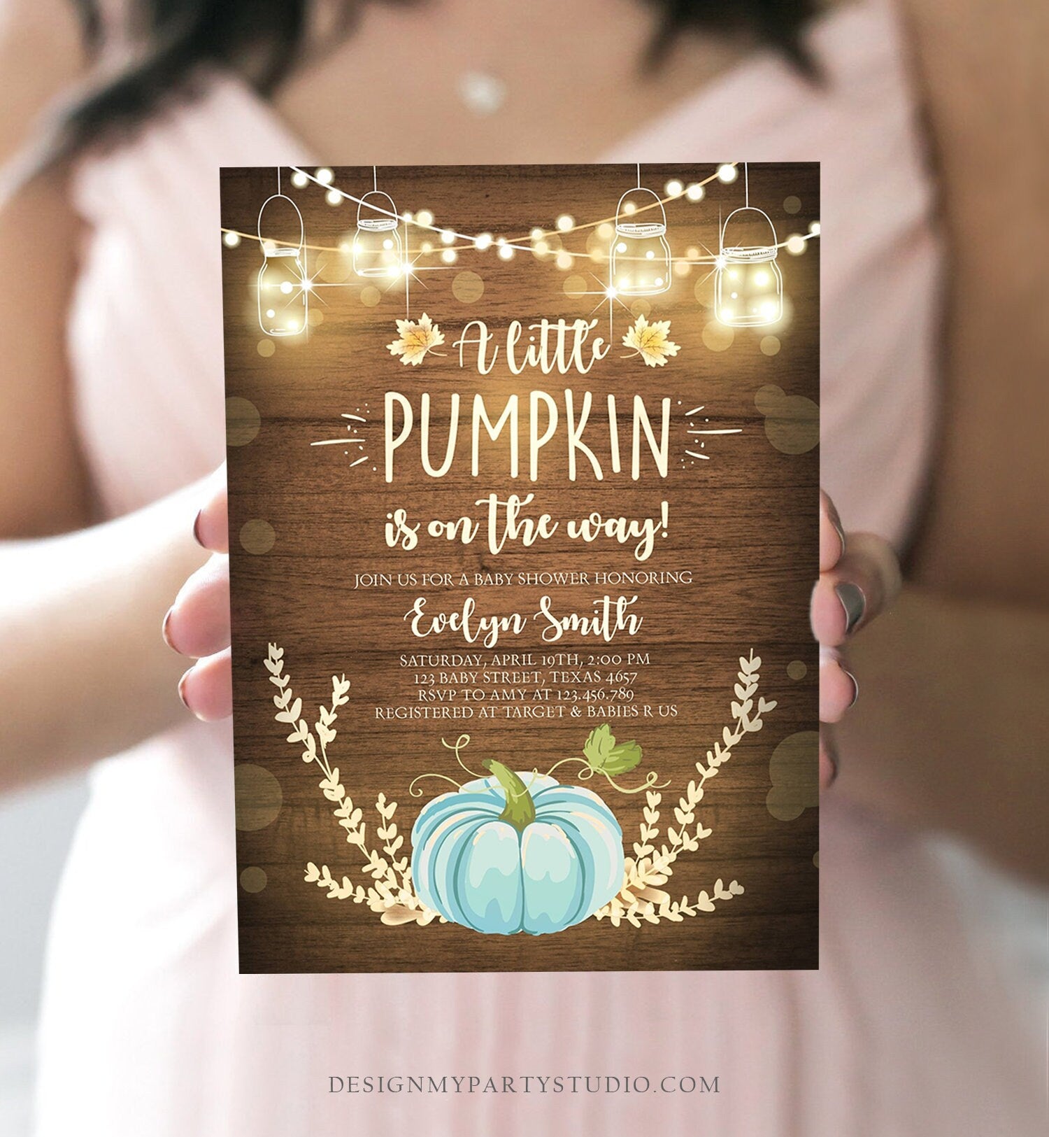 May include: A baby shower invitation with a rustic wood background and a blue pumpkin. The invitation reads &#39;A little pumpkin is on the way!&#39; and includes the name &#39;Evelyn Smith&#39;, the date and time of the shower, the address, and RSVP information. The invitation also includes the text &#39;Registered at Target & Babies R Us&#39;.