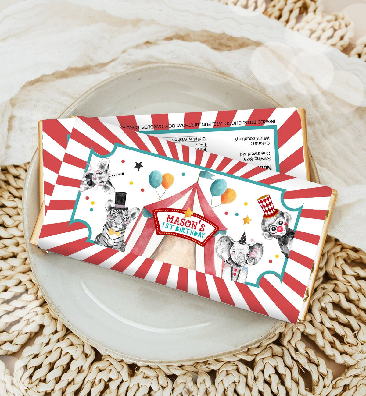 May include: A red and white striped chocolate bar wrapper with a circus theme. The wrapper features a tent, a tiger, an elephant, and a monkey. The text on the wrapper reads &amp;#39;Mason&amp;#39;s 1st Birthday&amp;#39;.