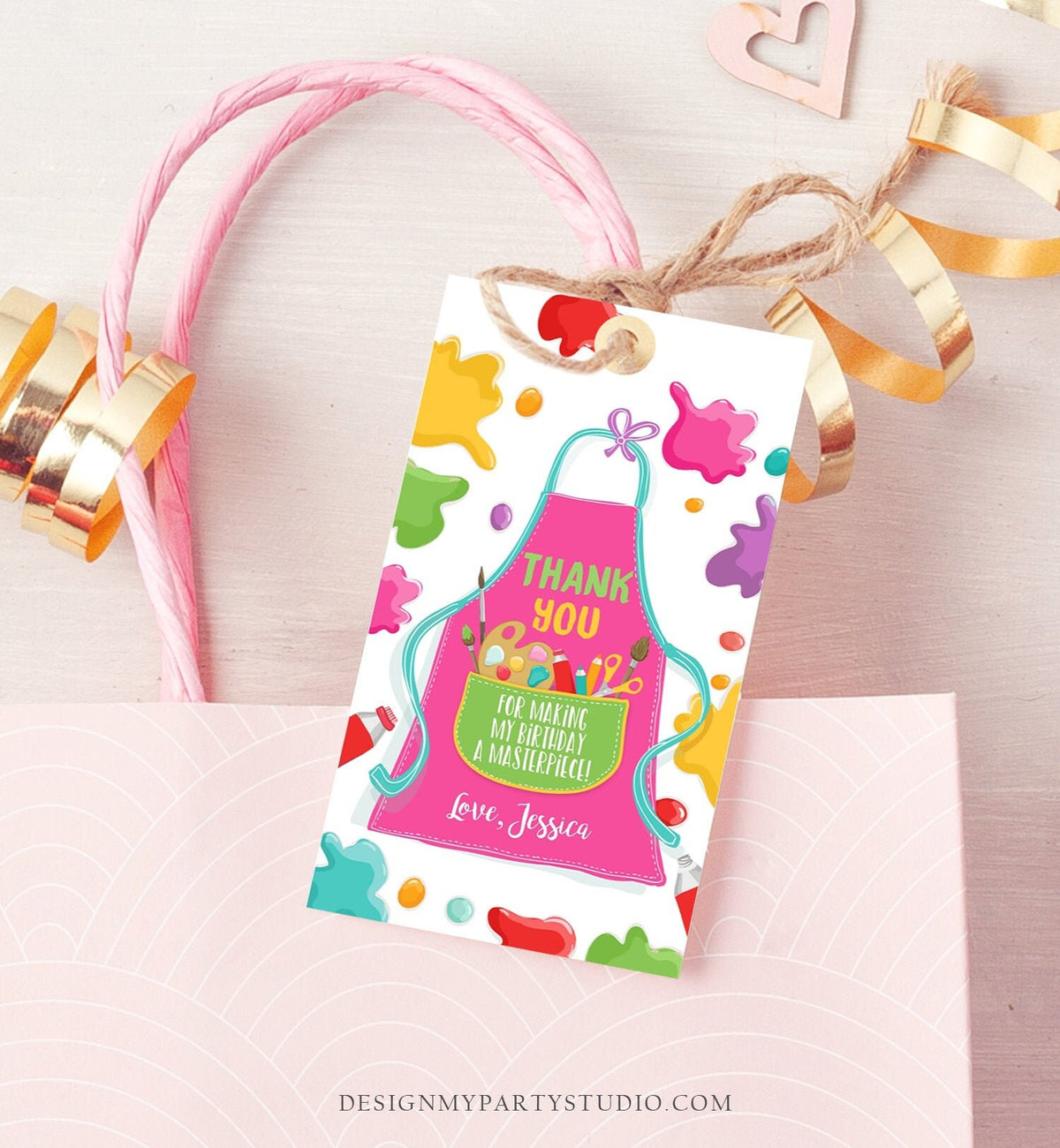 May include: A thank you tag with a pink apron design and colorful paint splatters. The text on the tag reads &amp;#39;Thank You for making my birthday a masterpiece! Love, Jessica.&amp;#39;