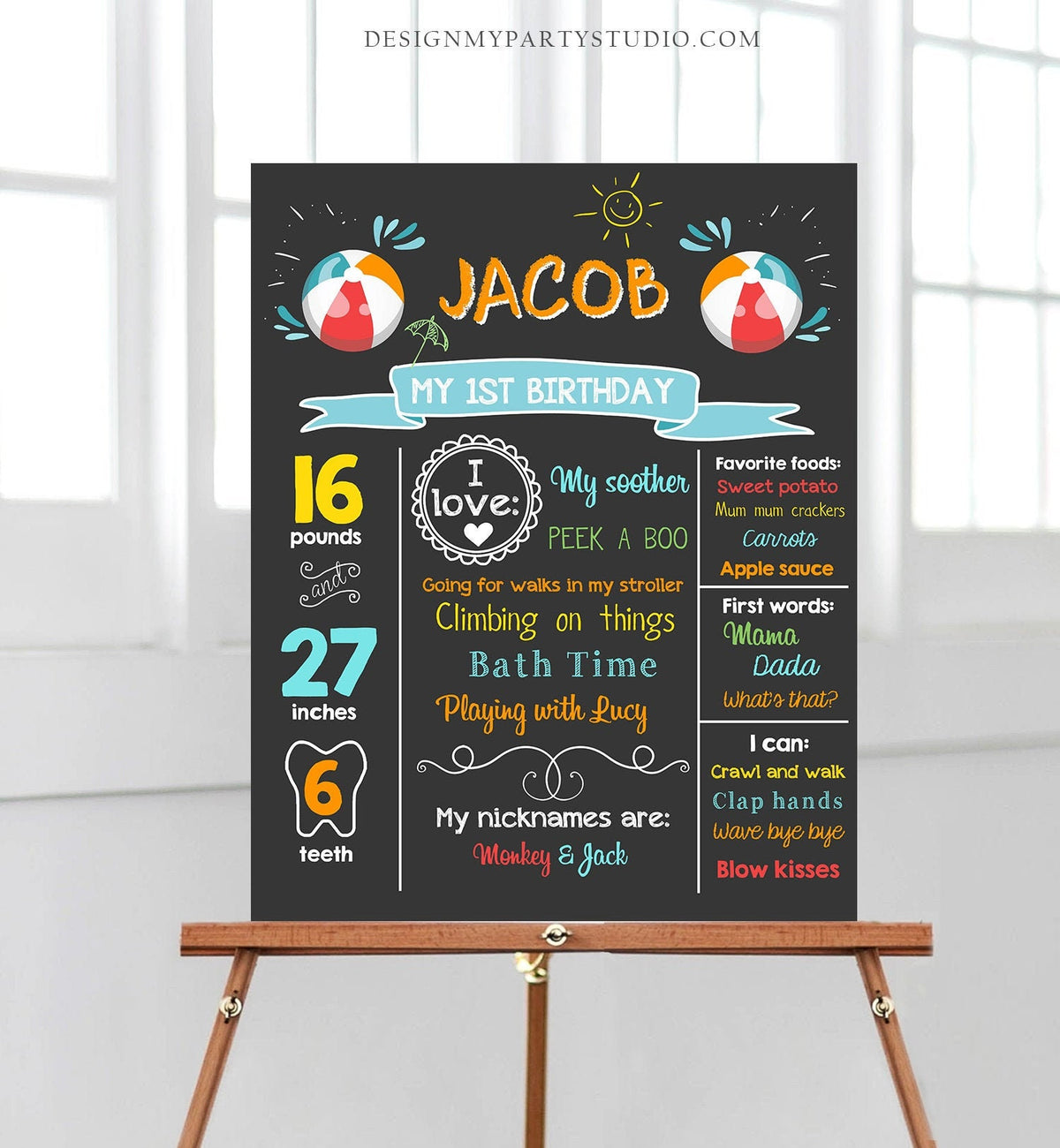 May include: A chalkboard style birthday sign with the name Jacob and the text &amp;#39;My 1st Birthday&amp;#39;. The sign is decorated with beach ball graphics and includes details about Jacob&amp;#39;s age, weight, height, favorite things, and milestones. The sign is on a wooden easel.