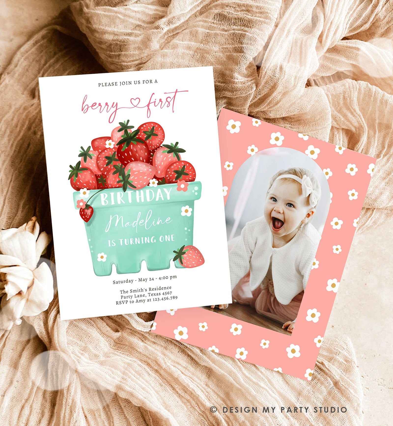 May include: A pink and white birthday invitation with a photo frame. The invitation has a green and white illustration of a basket of strawberries. The text on the invitation reads &#39;Please join us for a berry first birthday Madeline is turning one. Saturday May 24-4:00 pm The Smith&#39;s Residence Party Lane, Texas 4567 RSVP to Amy at 123.456.789&#39;.