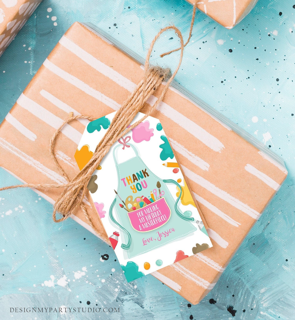 May include: A gift tag with a light blue apron design, featuring the text &amp;quot;THANK YOU&amp;quot; and &amp;quot;FOR MAKING MY BIRTHDAY A MASTERPIECE!&amp;quot; with the name &amp;quot;Jessica&amp;quot;. The tag is tied with twine to a wrapped gift with white stripes.