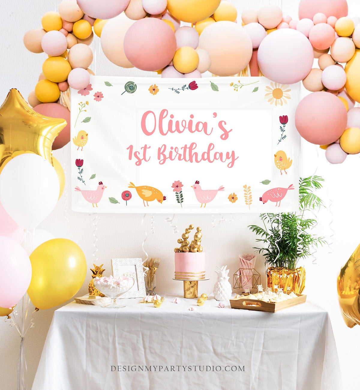 May include: A party scene with a banner that reads &amp;quot;Olivia&amp;#39;s 1st Birthday.&amp;quot; The banner is decorated with cartoon chickens and flowers. Balloons in shades of pink, yellow, and gold are arranged around the banner and table. A cake and other decorations are on the table.